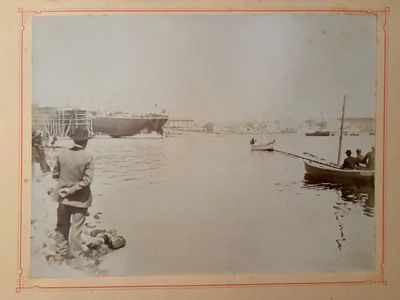 a black and white photo of a man standing on the beach