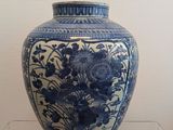 a blue and white vase on display in a glass case