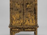 une vieille armoire en bois ornée d'une décoration dorée sur le dessus
