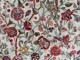 a close up of a rug with flowers and birds on it