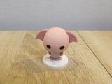 a small toy pig sitting on top of a wooden table