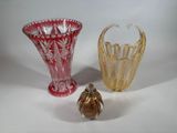 three different colored glass vases sitting next to each other on a white surface