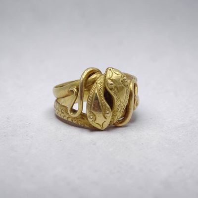 Gros plan sur une bague en or ornée d'un serpent