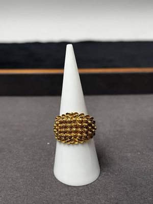 la bague en or repose au sommet d'un cône blanc