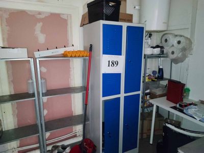 a blue and white locker in a room with shelves