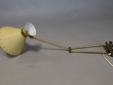 brass plated wall lamp with a white shade and a brass plated arm