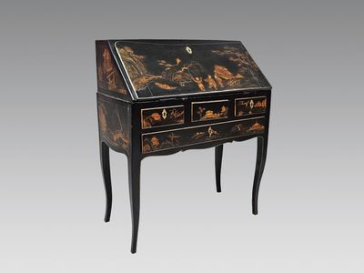 un bureau peint en noir et or, muni de tiroirs et de tiroirs
