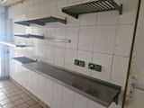 a kitchen with white tile walls and a metal counter