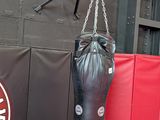 a man standing next to a punching bag in a gym