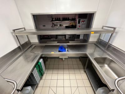 une cuisine avec des plans de travail en inox et un évier