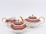 a pair of pink and gold teapots on a white background