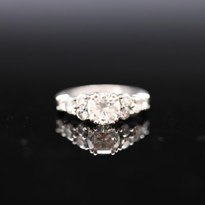 a close up of a diamond ring on a black surface
