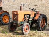 deux vieux tracteurs garés devant un bâtiment