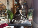 a statue of a woman sitting on top of a table