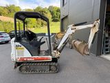 a small excavator that is parked in front of a building
