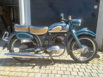 une moto bleue garée devant un garage