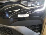 the front end of a black car with a white sticker on it ' s bumper