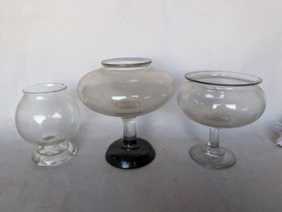 trois vases en verre posés l'un à côté de l'autre sur une table