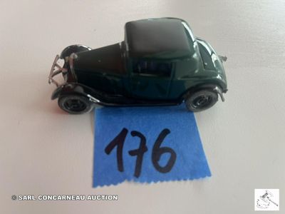 une petite voiture verte ornée d'un ruban bleu