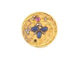 une photo en gros plan d'une broche plaquée or ornée de pierres bleues et roses