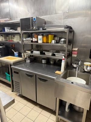 une grande cuisine en inox avec beaucoup de plans de travail