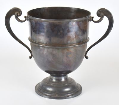 une coupe en argent posée sur un socle