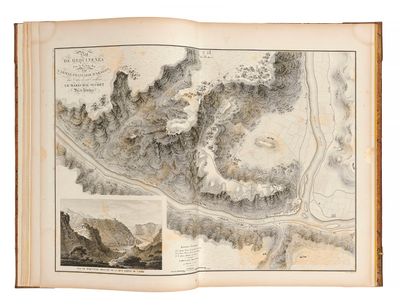 un livre ouvert dans lequel figure une carte représentant une rivière et des montagnes