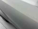 the car is shiny silver and has a small crack in the side of the door