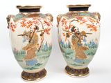 pair of asian vases with asian figures on them on a white background