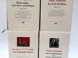 trois livres posés sur une table blanche, ornée d'un ruban bleu