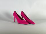 un gros plan sur une paire de chaussures à talons hauts roses posées sur une surface blanche