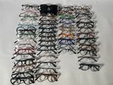 de nombreuses paires de lunettes disposées sur une surface blanche