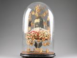 a glass dome with a clock inside of it on a table