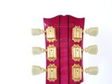 the headstock of an electric guitar with gold hardware on a white background