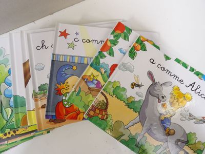 several children ' s books are lined up on a table