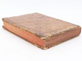 an old book that is sitting on a white surface