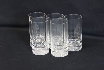 quatre verres transparents sont alignés sur une surface noire