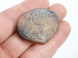 someone is holding a silver locke with a design on it