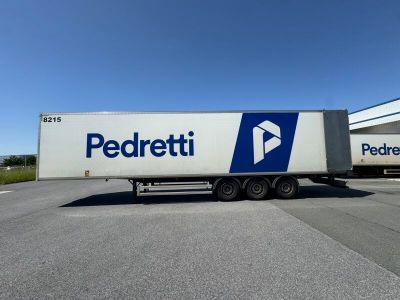 the semi truck is parked in front of a large building
