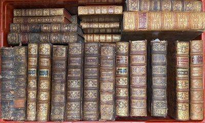 de nombreux livres anciens dans une boîte rouge posée sur l'étagère