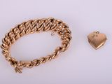 a gold bracelet and a heart charm on a white background