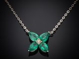 a close up of a necklace with a green flower on it