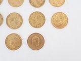 several different types of gold coins on a white surface