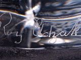 a glass vase with a name on it on a black surface