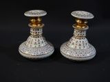 deux vases blancs et dorés placés l'un à côté de l'autre