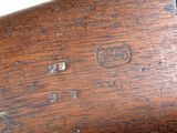 an old rifle with a wooden handle on a white surface