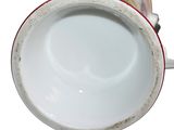 a close up of a coffee cup on a white surface