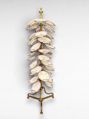 une photo d'une sculpture composée de coquillages posée sur un socle