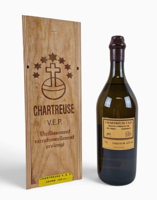 the bottle of chartreuse is next to a wooden box