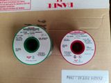 two spools of red and green thread on a brown box